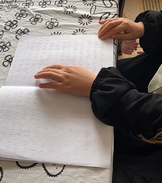 A student reading Arabic braille